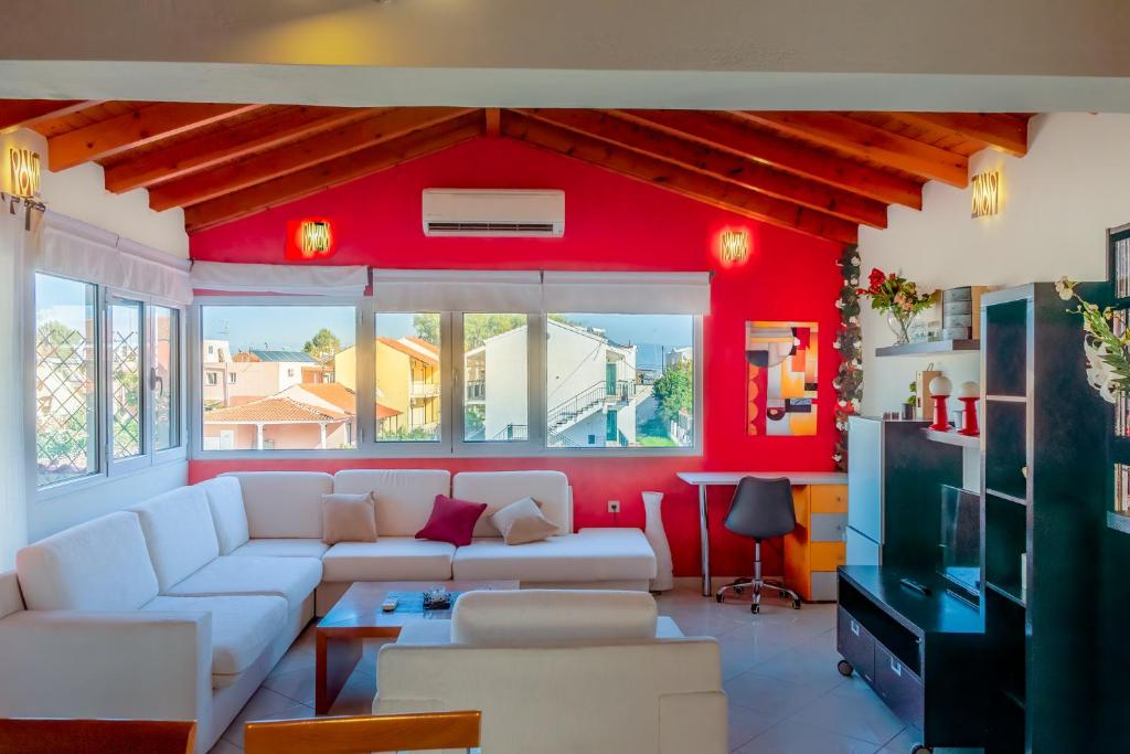 a living room with red walls and white furniture at Elisavet Apts in Kavos