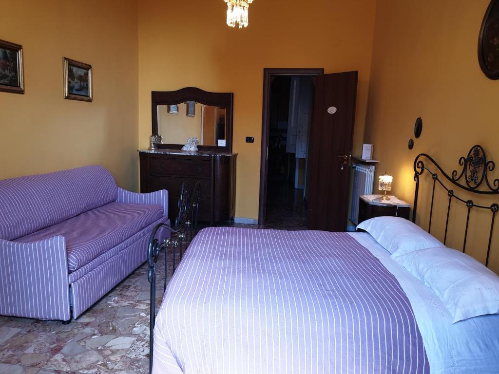 a bedroom with a bed and a couch and a mirror at A Casa di Mamma in Naples