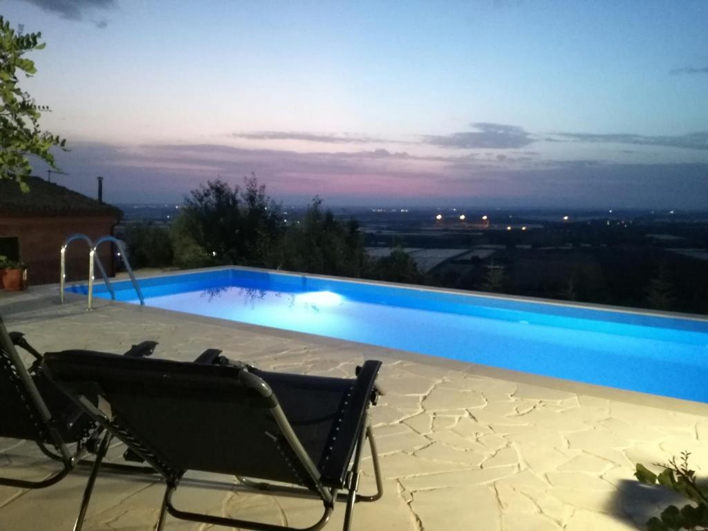 uma piscina com uma cadeira ao lado em La Pietra em Chiaramonte Gulfi