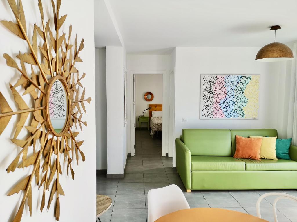 - un salon avec un canapé vert et un miroir dans l'établissement The Blue Corner Apartments, à Puerto de la Cruz