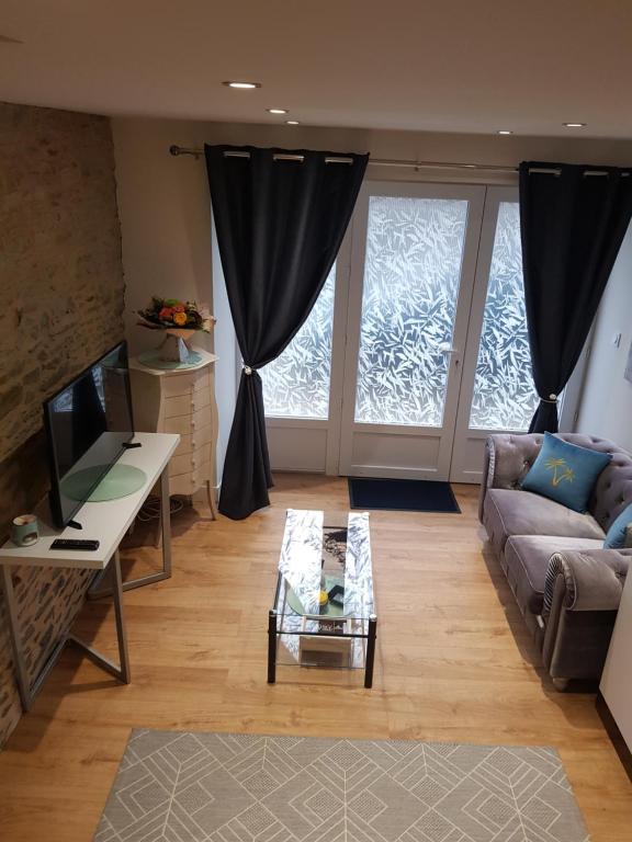 een woonkamer met een bank en een salontafel bij Au Mont Pour Deux in Pontorson