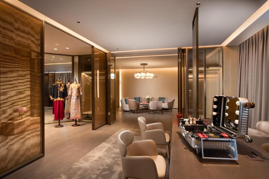 InterContinental Xi'an Hi-Tech Zone في شيان: غرفة ملابس مع طاولة زينة وصالون