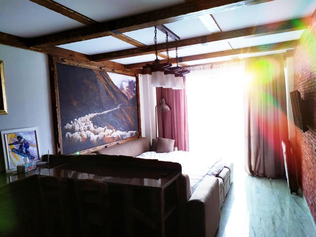 a bedroom with a couch and a large painting on the wall at Light Apartments in Gudauri