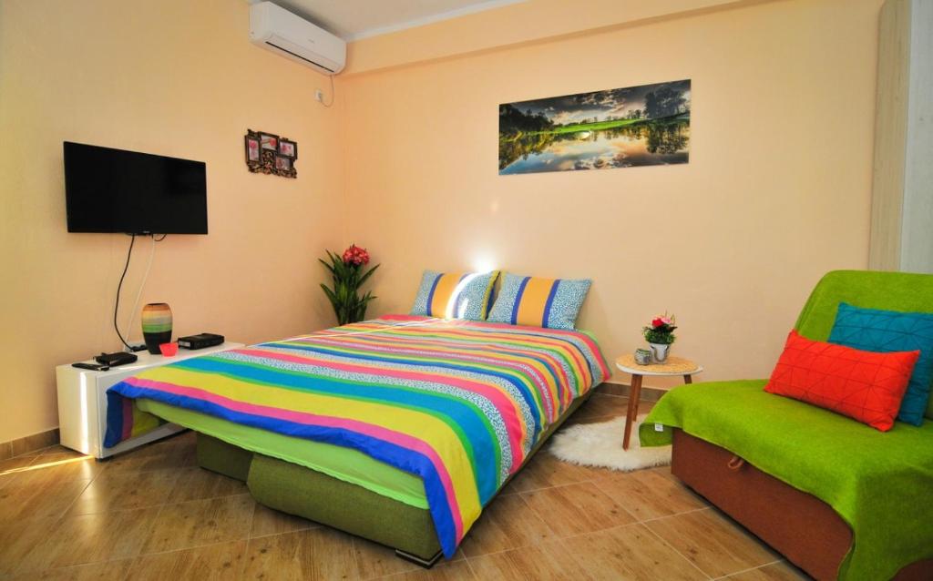 1 dormitorio con 1 cama colorida y 1 silla en Apartments M&T, en Tivat