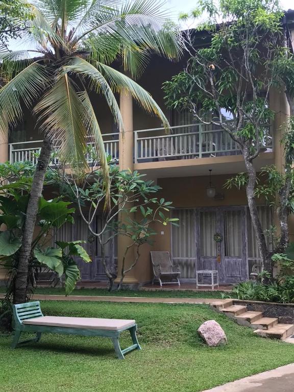 a park bench in front of a house at Aurora in Unawatuna