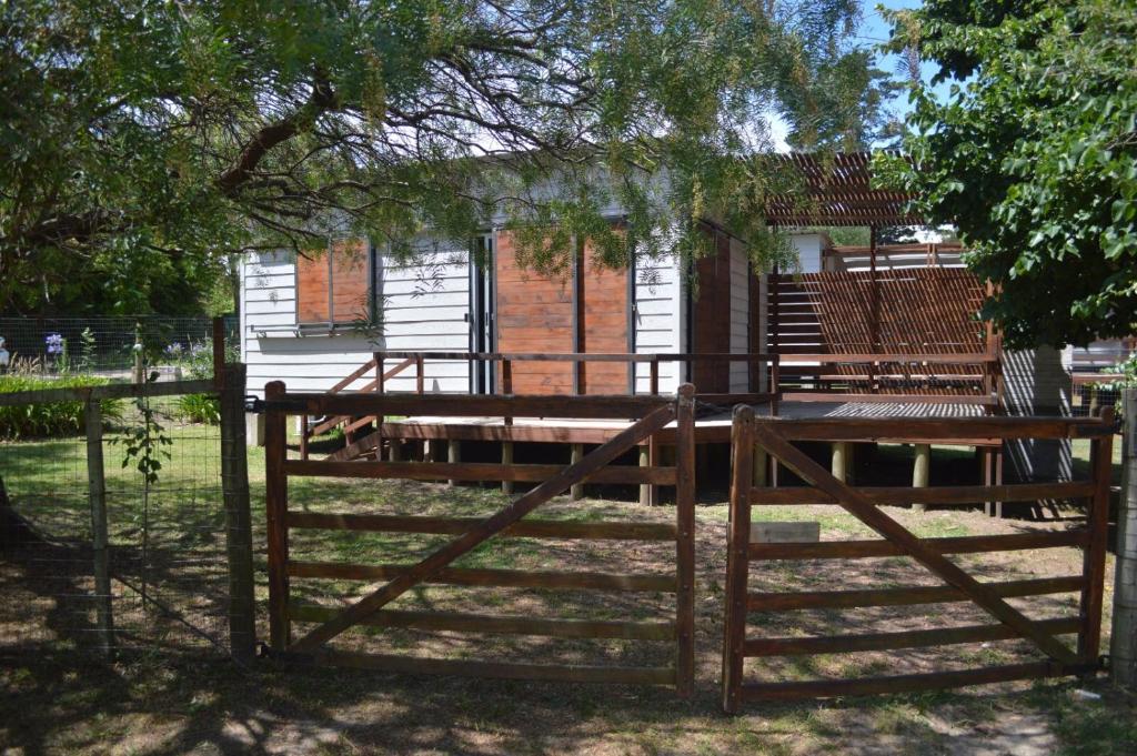 una valla de madera con bancos frente a una casa en Tu Lugar Solís en Piriápolis