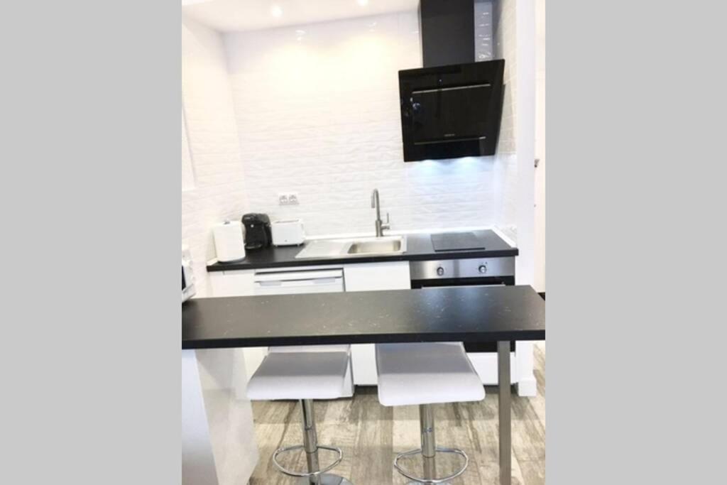 a kitchen with a sink and a counter with stools at Estudio Estilo Nórdico Madrid (Malasaña Gran Vía) in Madrid