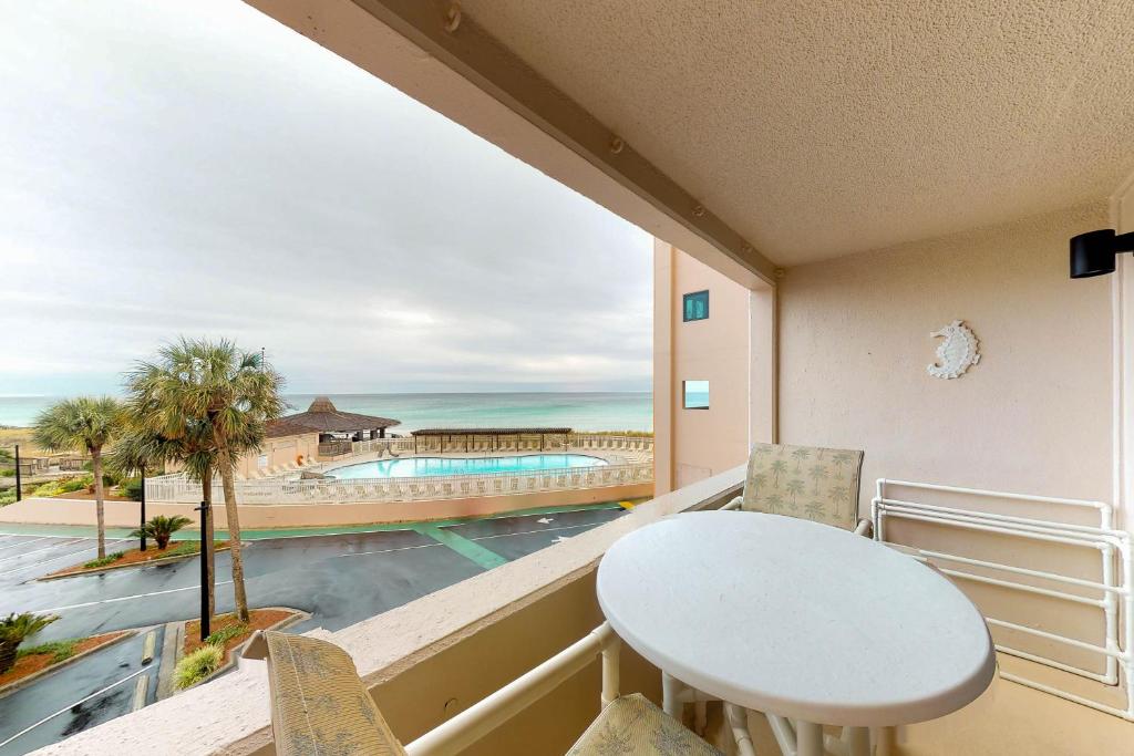 a balcony with a table and chairs and a view of the ocean at Jetty East Condos in Destin