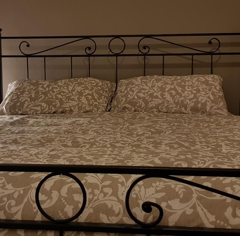 a bed with a metal frame and two pillows at Sweet Home in Falconara Marittima