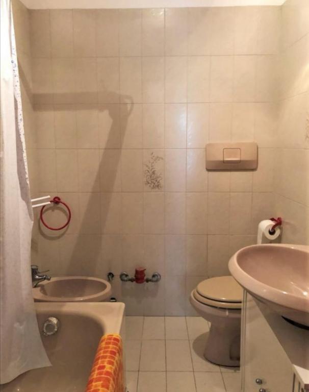 W łazience znajduje się toaleta, wanna i umywalka. w obiekcie Condominio Ginepro w mieście Carisolo