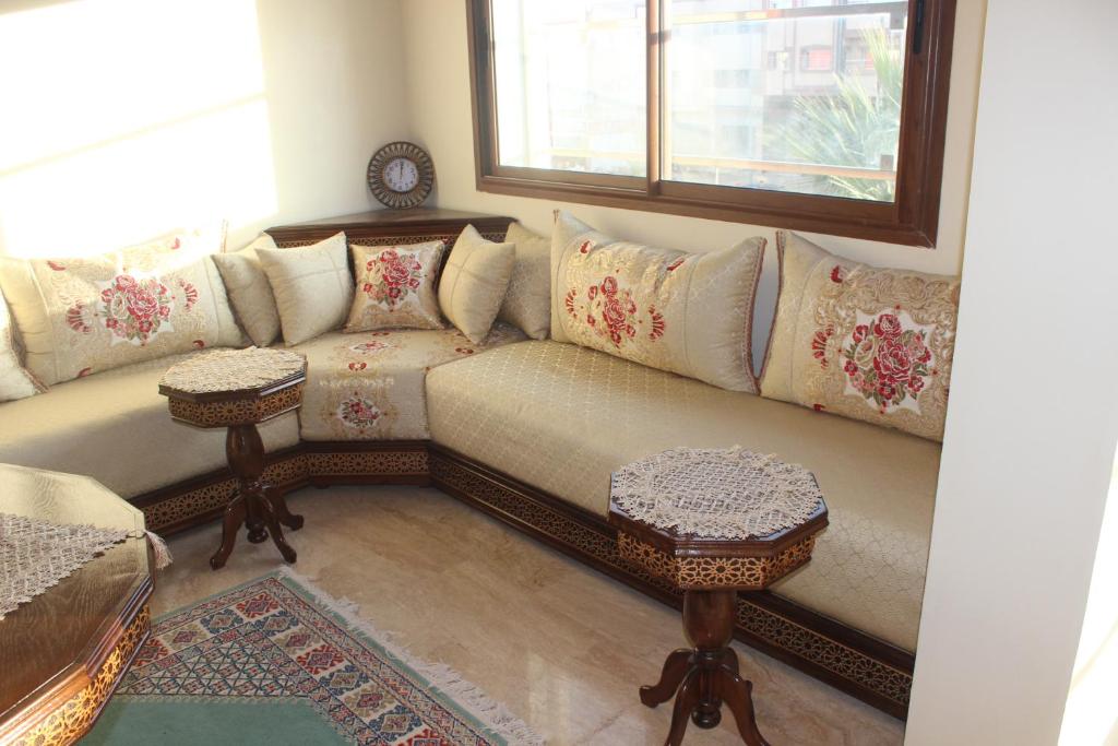 sala de estar con sofá y ventana en New Fez Apartments en Fez
