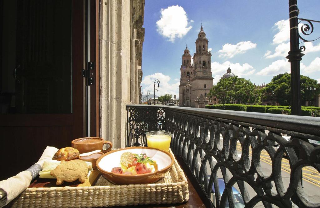 a plate of food on a balcony with a view of a building at Hotel Casino Morelia in Morelia