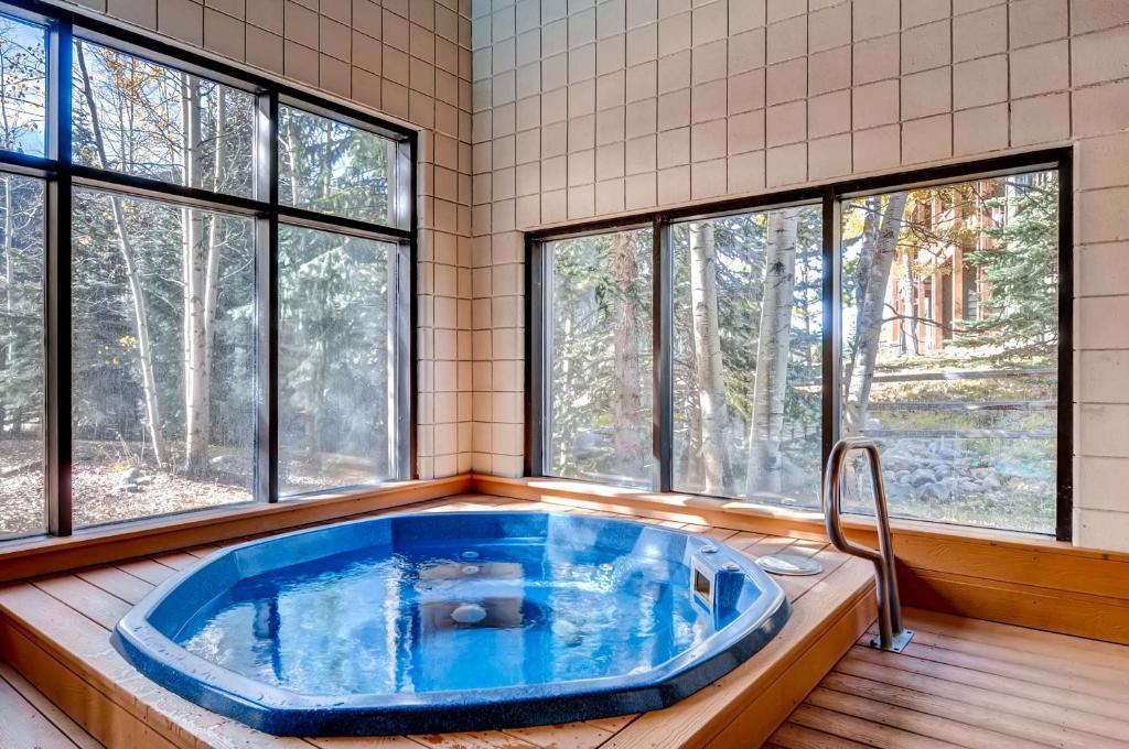 eine große blaue Badewanne in einem Zimmer mit Fenstern in der Unterkunft Ski Run Condominiums #108 in Keystone
