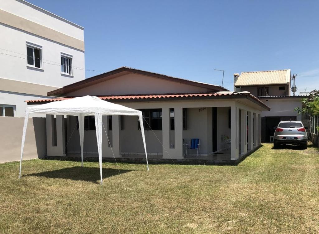 a white tent in front of a house at Casa à Beira Mar para Temporada in Sombrio