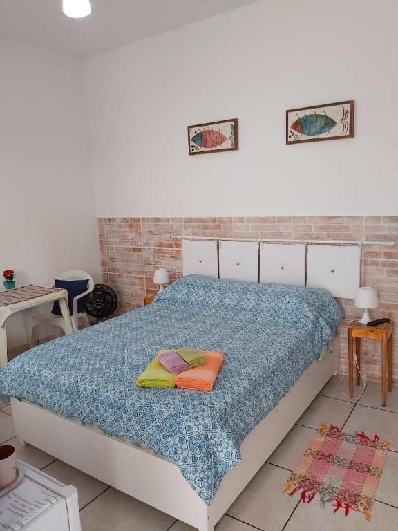 a bedroom with a bed with two pillows on it at Maranata Suítes in Peruíbe