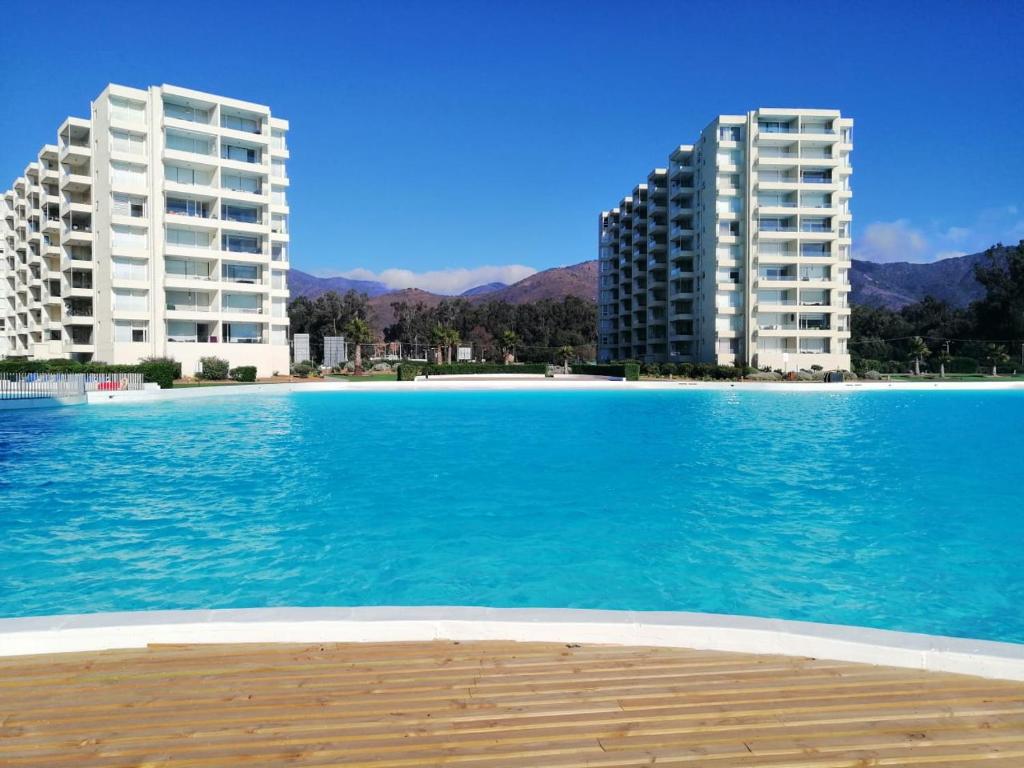 2 edificios de apartamentos y una piscina de agua azul en Papudo Laguna, Hermoso Apartamento junto al Mar, en Papudo