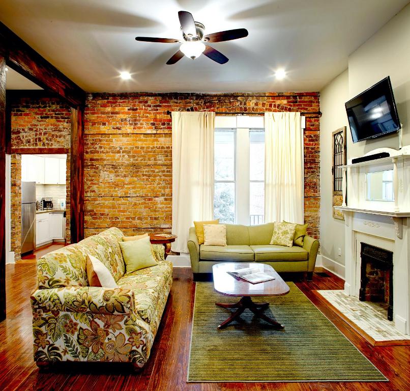 Newly Renovated Historic Savannah Townhome! في سافانا: غرفة معيشة مع أريكة ومدفأة