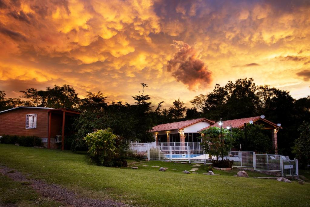 a house in a yard with a cloudy sky at Vista Alegre Natural Resort - Bungalows in Independencia