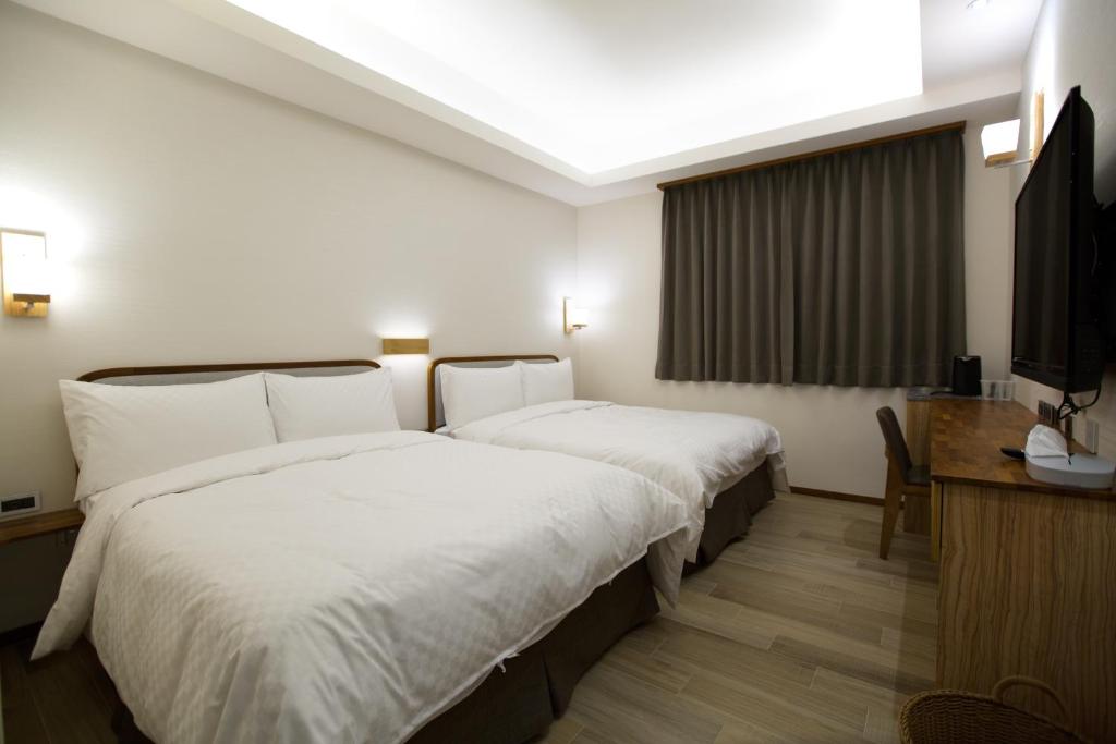 Postel nebo postele na pokoji v ubytování 原鄉商旅 Yuan Hsiang Hotel