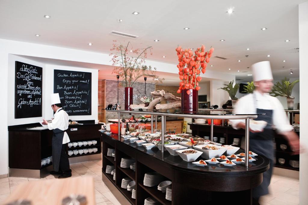 two chefs standing in front of a buffet of food at Holiday Inn Munich City Centre, an IHG Hotel in Munich