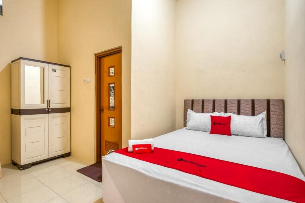 Un pat sau paturi într-o cameră la RedDoorz Syariah near Kebon Rojo Park Blitar