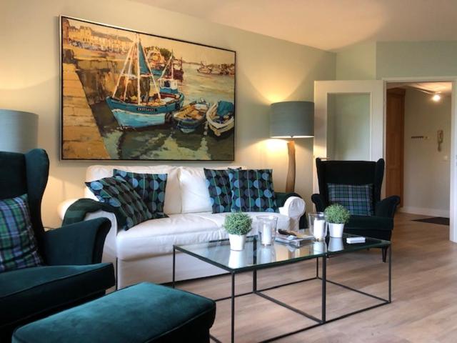 un soggiorno con divano bianco e un dipinto di barche di Luxury Apartment Axams a Innsbruck