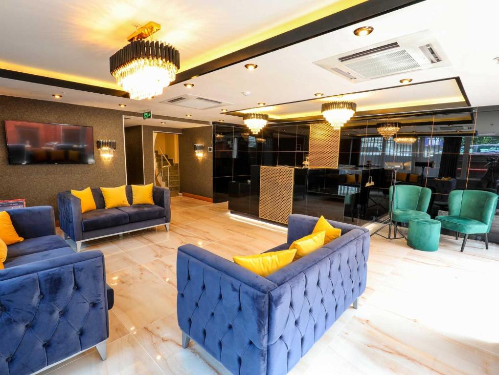 een lobby met blauwe banken en gele kussens bij Grand Elmira Suites in Istanbul