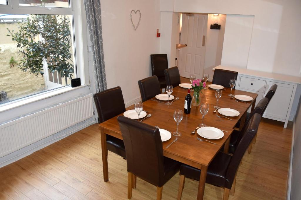 a dining room with a wooden table and chairs at Cornish Townhouse Central Newquay with Parking - Simply Check In in Newquay