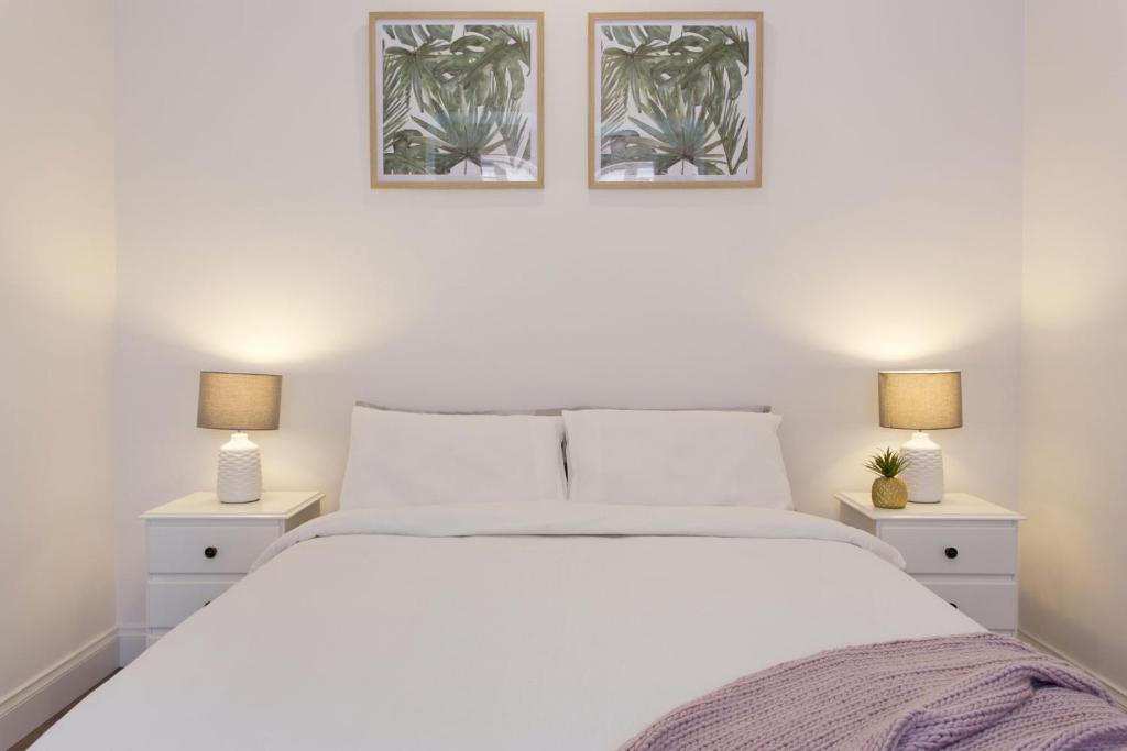 1 dormitorio con 1 cama blanca y 2 lámparas en Emu at White Gum Lodge, en Fremantle