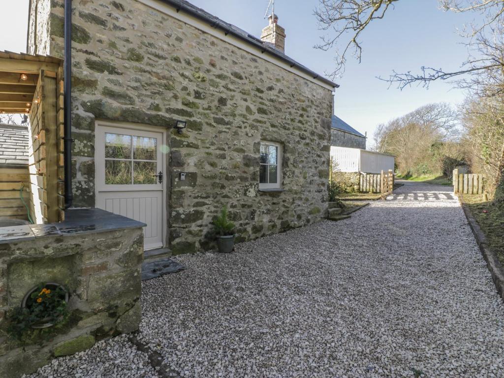 a stone house with a stone driveway at Owl Cottage in Pwllheli