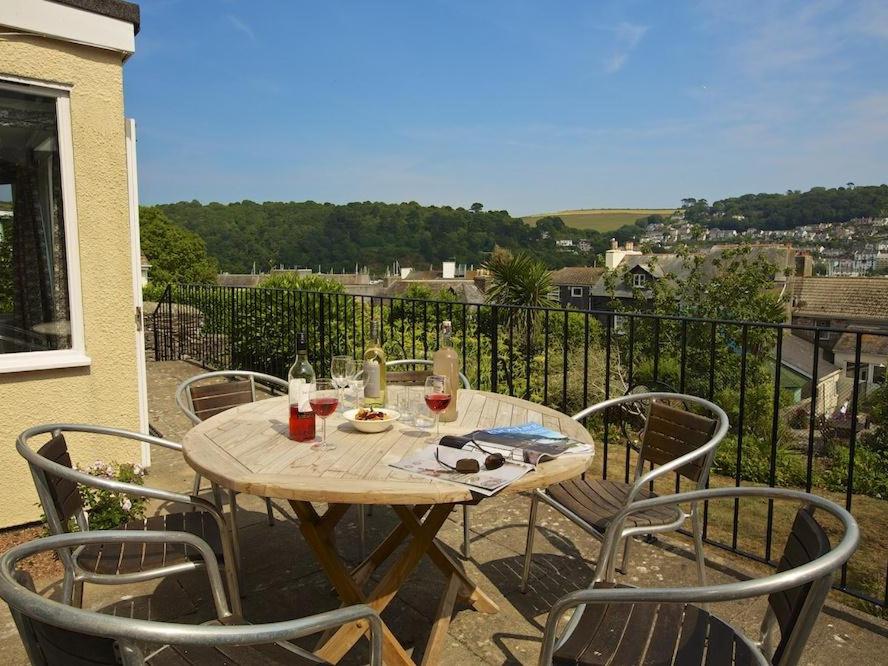 ein Holztisch und Stühle auf einem Balkon in der Unterkunft Moonrakers, Clarence Street in Dartmouth