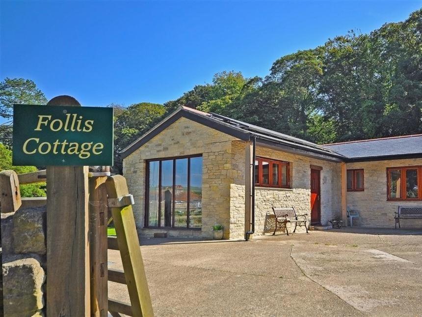 a house with a sign in front of it at Follis Cottage in Weymouth