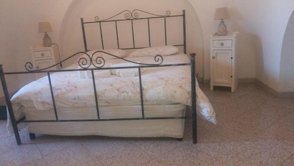 a bedroom with a bed and two night stands at Dimora Sumerano in Alberobello