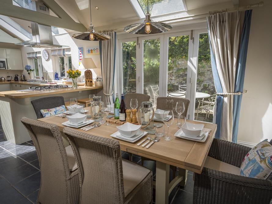 una sala da pranzo con tavolo e sedie e una cucina di Gooder House a Dartmouth