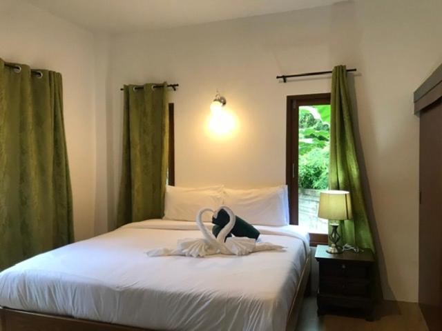 ein Schlafzimmer mit einem Bett mit einem ausgestopften Tier darauf in der Unterkunft Green Villa in Lamai