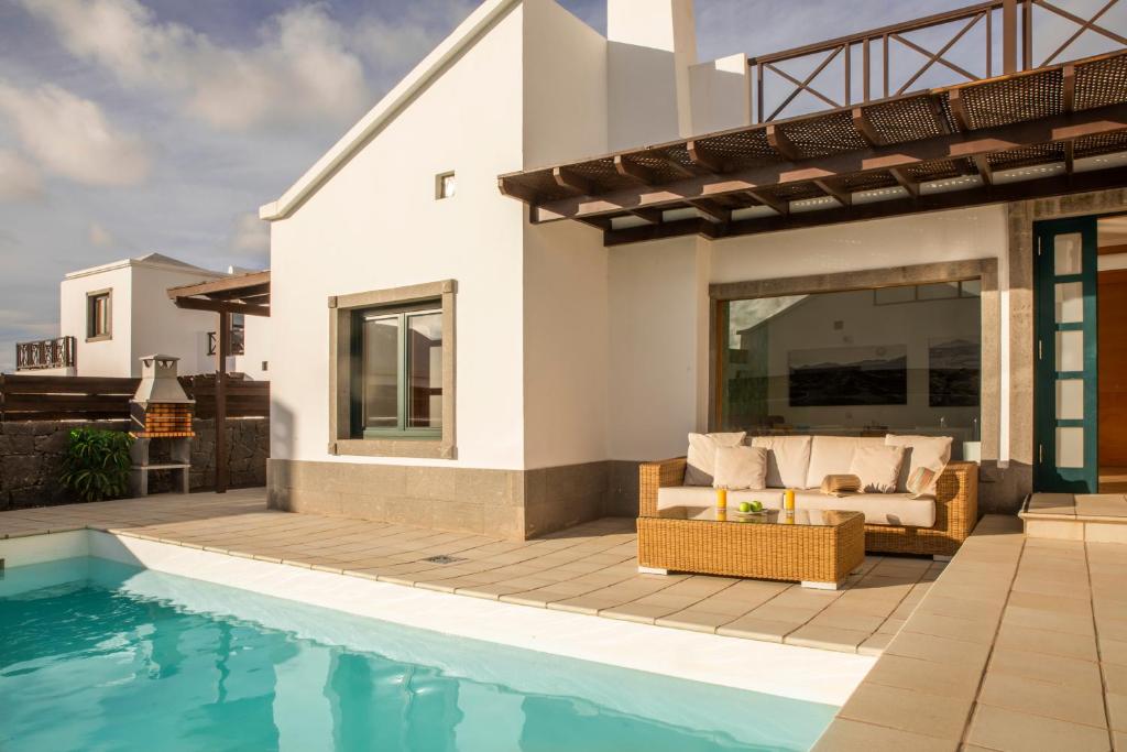 a villa with a swimming pool and a house at Playa Blanca Beach Mate in Playa Blanca