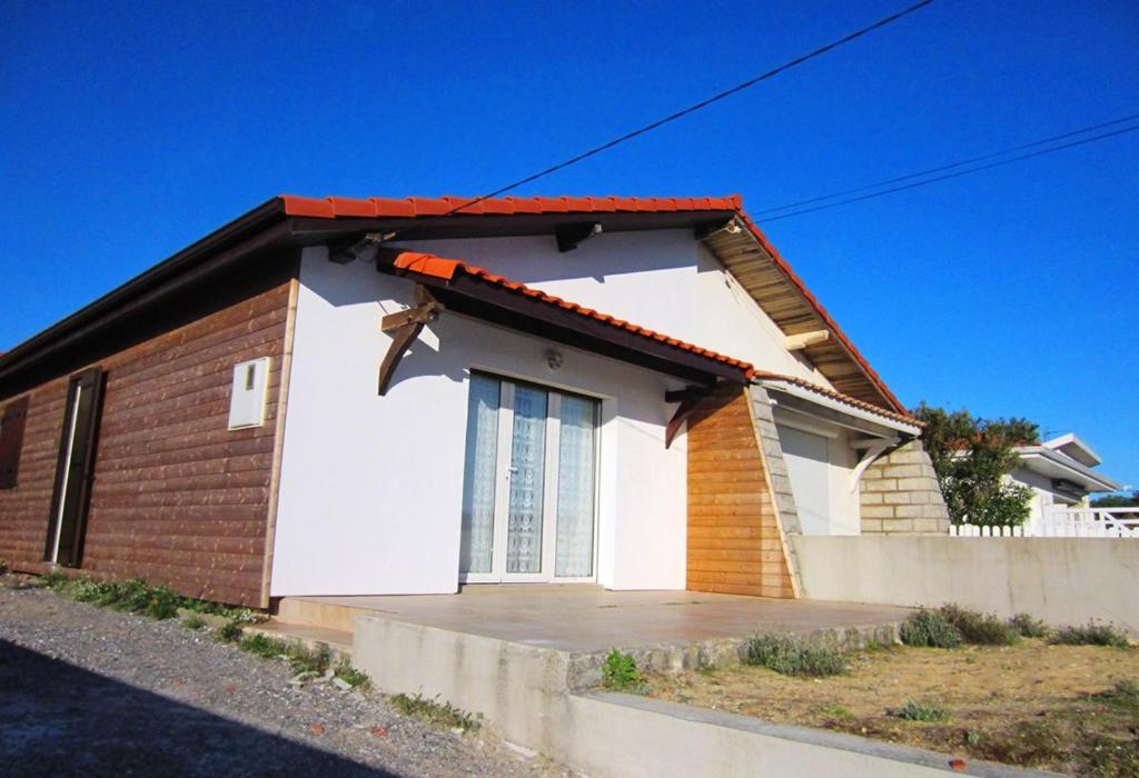 una pequeña casa blanca con techo rojo en Appartement Pour 4 Personnes Dans Villa Dans Le Vent en Hossegor
