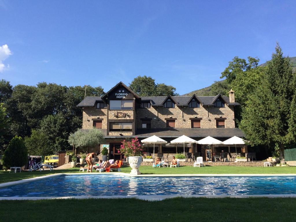 un gran edificio con una piscina frente a él en Hotel Florido, en Sort