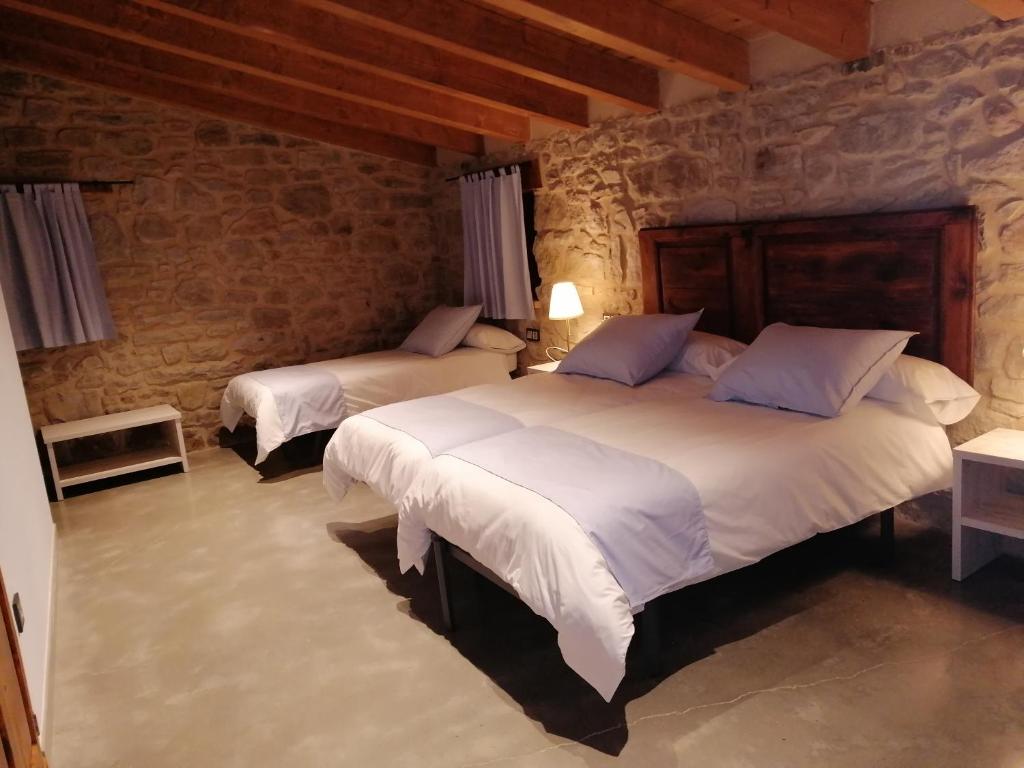 Un pat sau paturi într-o cameră la Cal Teixidor - La Fusteria