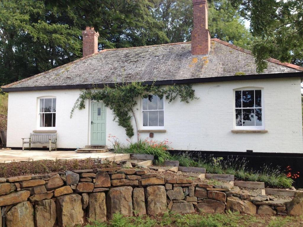 a white house with a stone wall at Hedgelea in Winkleigh
