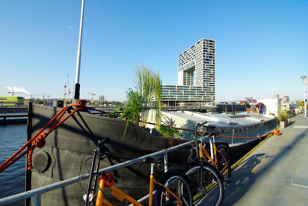 due biciclette parcheggiate accanto a una barca in acqua di Eco HouseBoat ad Amsterdam