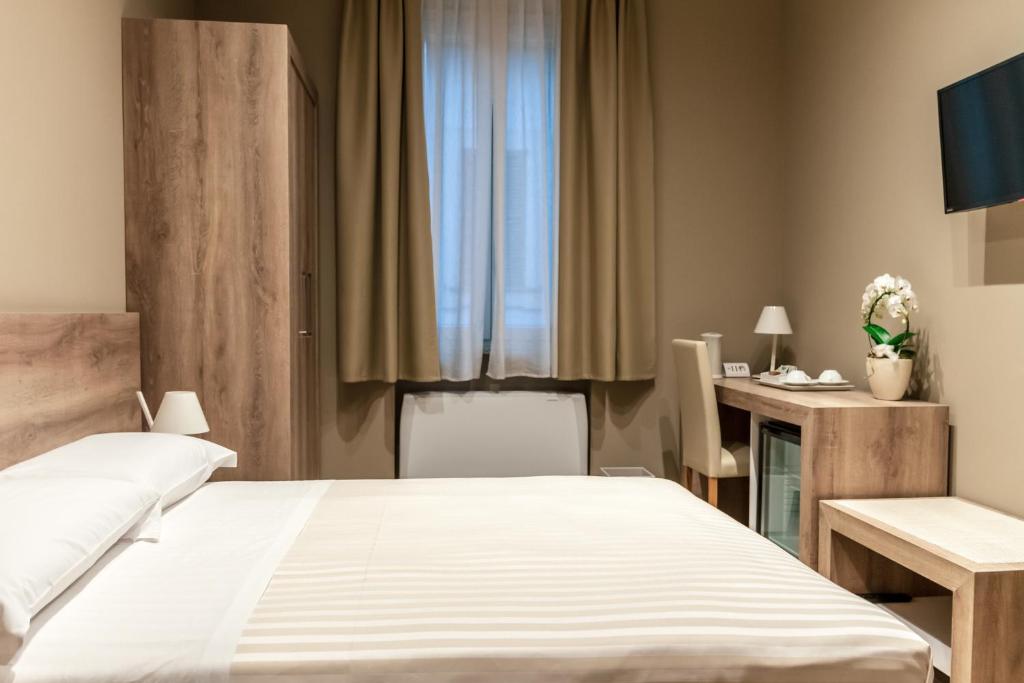 um quarto de hotel com uma cama e uma secretária em Delight Rooms em Corbetta