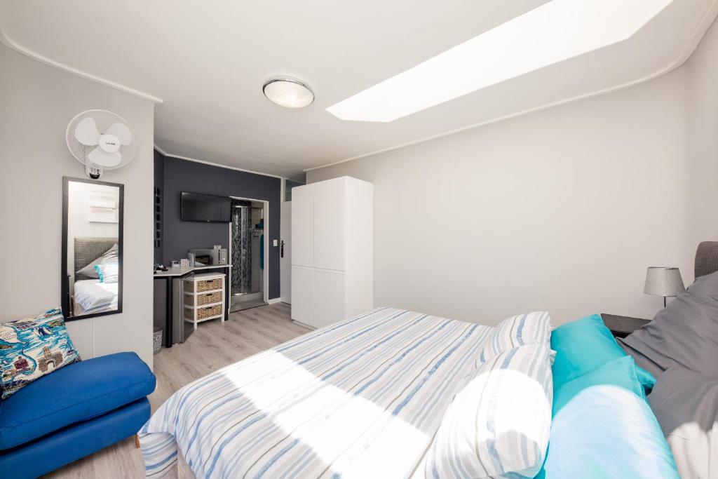 a bedroom with a bed and a television in it at Big Blue Accommodation in Bloubergstrand
