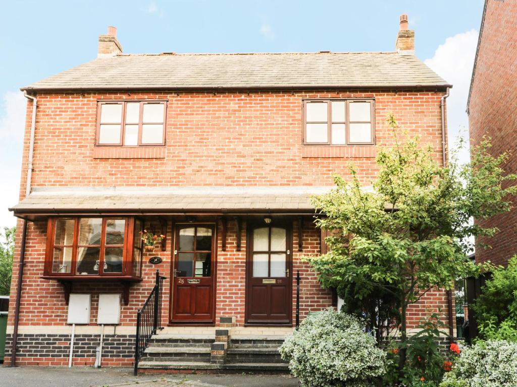 a red brick house with a brown door at Eskview Cottage in Whitby