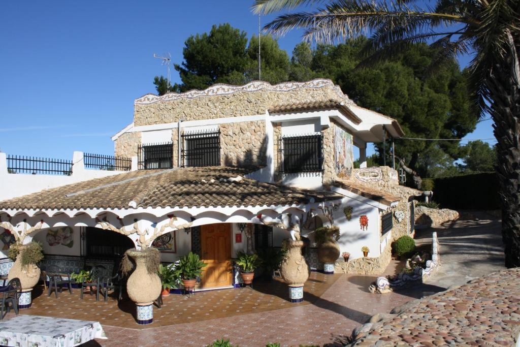 uma casa com um alpendre e um pátio com plantas em "La Chacra" Casa Típica Valenciana em Godella