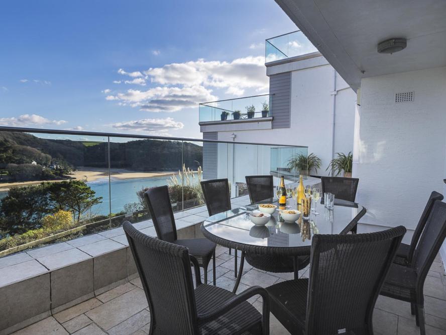 Un comedor con mesa y sillas en un balcón. en 2 Hamstone Court, en Salcombe