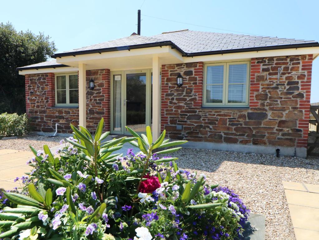 a brick house with flowers in front of it at Elm Cottage in Truro