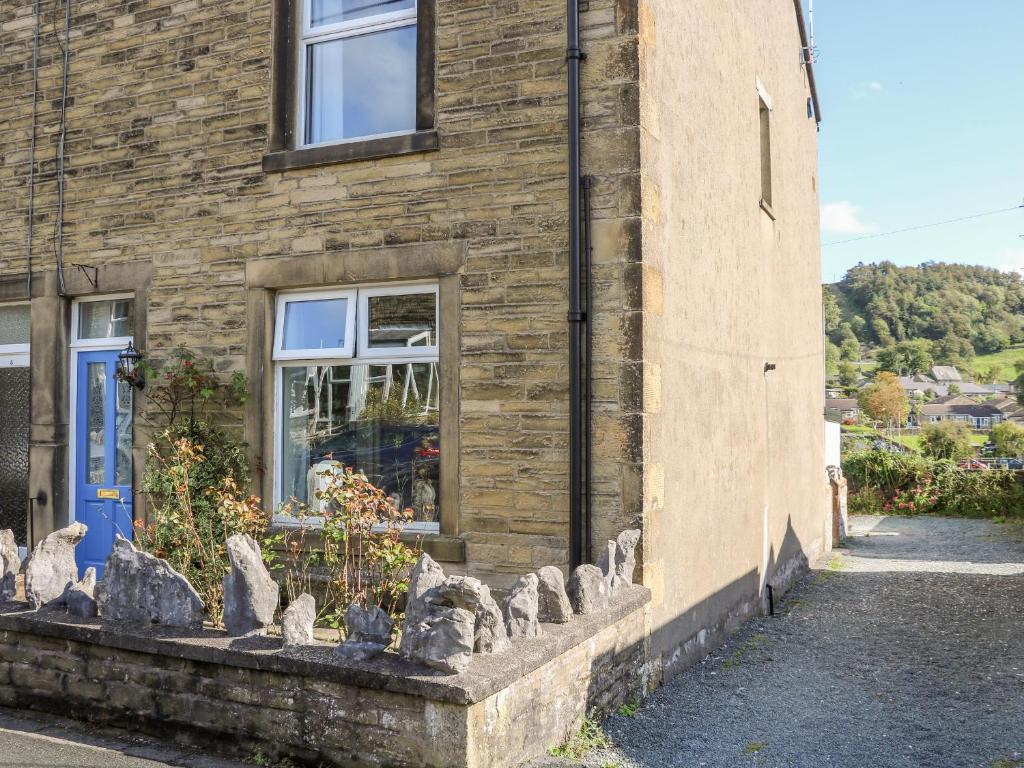 a stone house with statues in front of it at West View Cottage in Settle