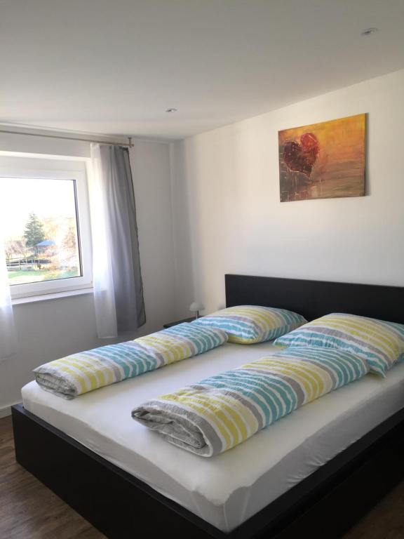 two pillows on a bed in a room with a window at Valley ferienwohnung SÜW in Heuchelheim-Klingen