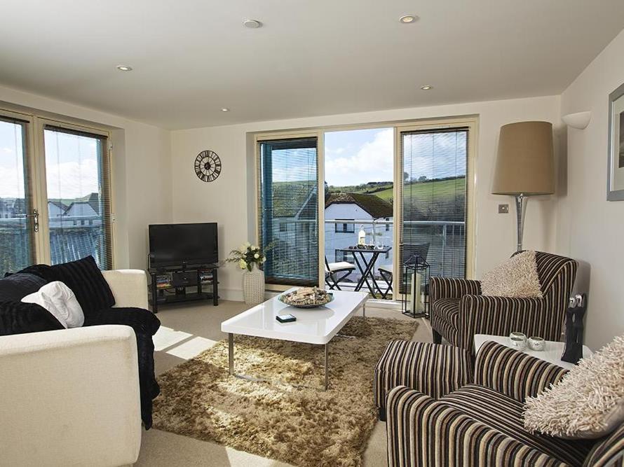 a living room with two couches and a table at Estuary View in Kingsbridge